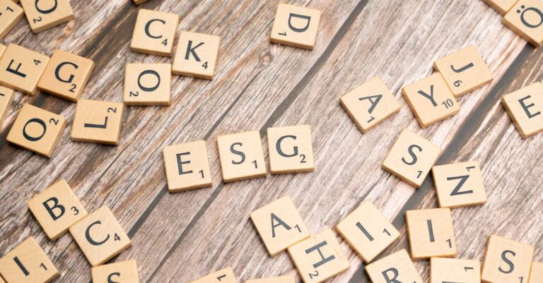 Wooden letter tiles spell ESG on a rustic wooden surface, emphasizing sustainability.