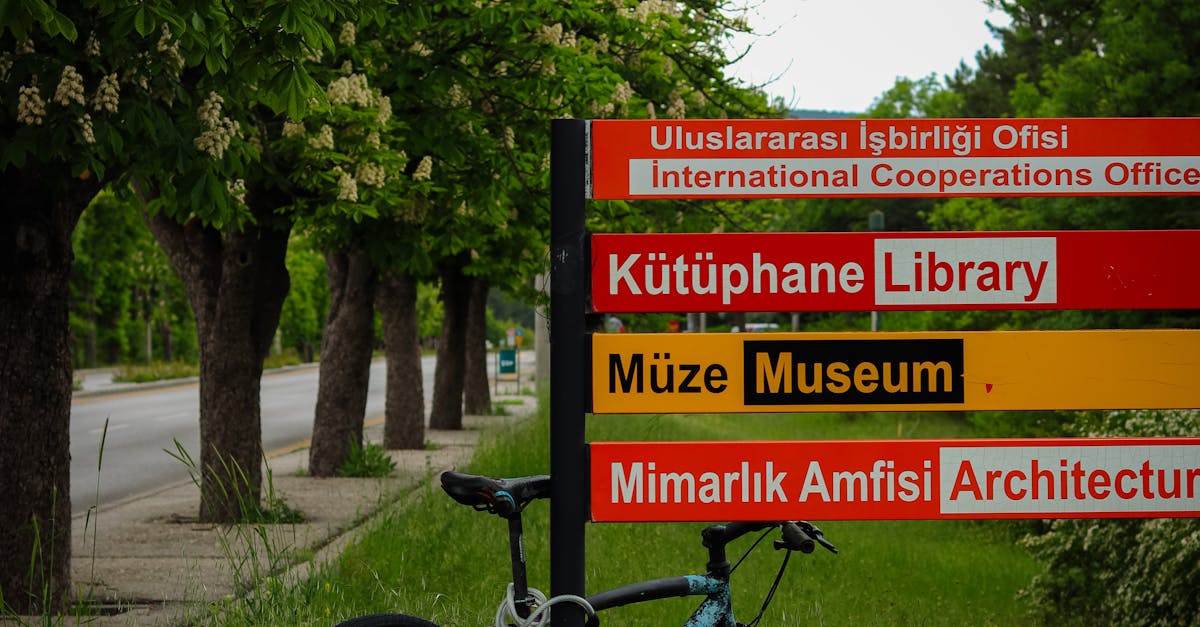 A bicycle parked on grass beside a multilingual sign in Ankara, Turkey.