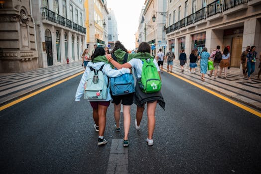 Three young friends walk arm-in-arm on a Lisbon street, showcasing friendship and travel spirit.