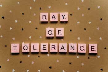 Pločice ispisom „Dan tolerancije“ na dizjajniranoj pozadini sa uzorkom srca,